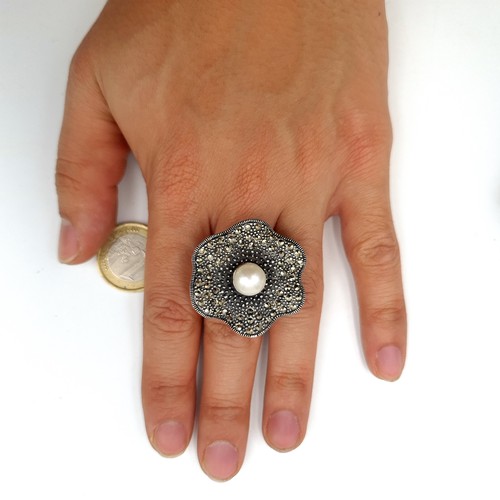 487 - A fabulous sterling silver cocktail ring, set with a central pearl and Marcasite scalloped mount. Ri... 