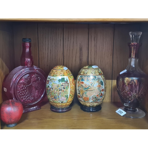 850 - Four items including a bohemian cranberry glass decanter, two decorative oriental hand painted eggs ... 