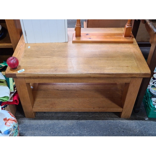 855 - A nicely sized solid oak coffee table with under storage. In good order