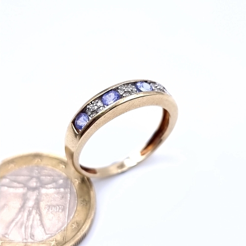 889 - Star Lot : A striking 9 carat gold wide banded Diamond and Tanzanite ring, featuring nicely set Diam... 