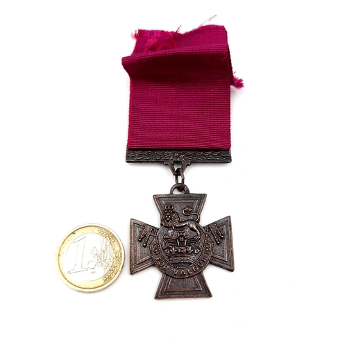 938 - A reproduction medal of the Victoria cross medal for valour with purple ribbon.