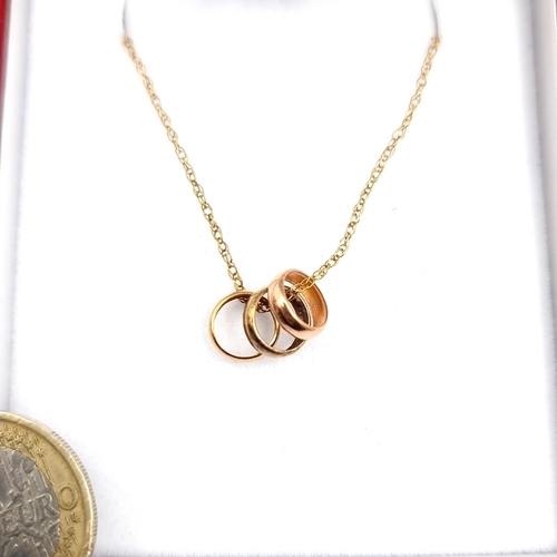 955 - A delicate 9ct Gold Necklace with a trio of hoop charms. With hallmark. Weight 1.17g. With presentat... 