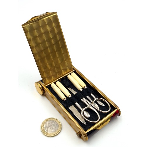 939 - A striking 20th century vanity compact comprising of a manicure set with scissors, file and cuticle ... 