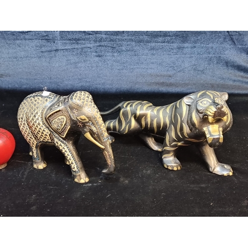 118 - Two unusual cast metal figures depicting a vibrant elephant and a tiger. Featuring elaborate decorat... 