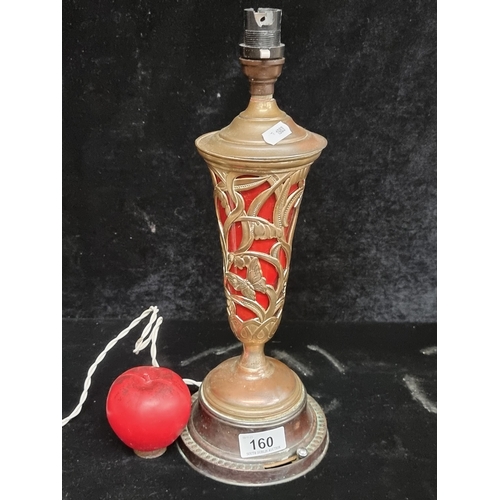 160 - A stunning Art Nouveau table lamp with pierced brass body containing a ruby glass shade. Both the ma... 