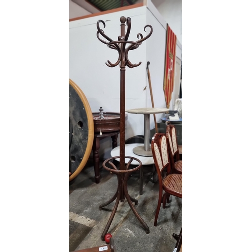 746 - A handsome mid century bentwood coat stand with 12 hooks and umbrella stand to base.