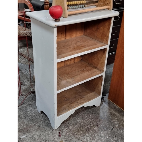 762 - A charming vintage shelving unit with three shelves and carved apron. In an off white finish.