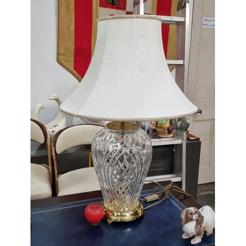 770 - Star Lot A very large Waterford Crystal table lamp with brass fittings and cream shades. Fitted with... 