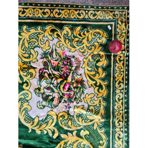 765 - A very colourful large velvet throw with a green ground background and a yellow plain lined back. Co... 