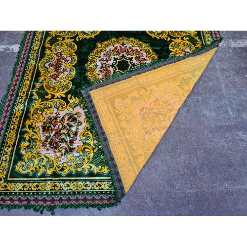 765 - A very colourful large velvet throw with a green ground background and a yellow plain lined back. Co... 