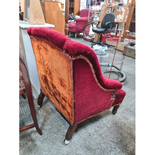 757 - A victorian  century nursing chair with plush red upholstery and castors to back legs. Nice shape to... 