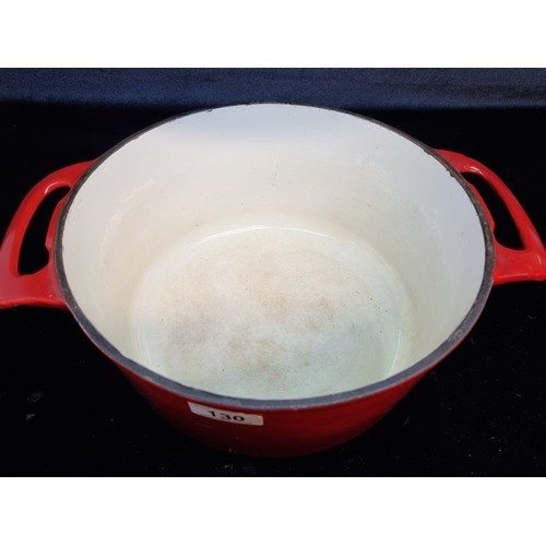 130 - A large Le Creuset cast iron pot with lid. In a red finish.