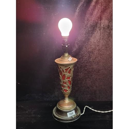 160 - A stunning Art Nouveau table lamp with pierced brass body containing a ruby glass shade. Both the ma... 