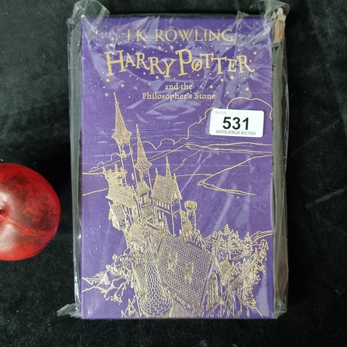 An exquisite edition "Harry Potter and the Philosopher's Stone" by J.K. Rowling, published by Bloomsbury in 2015. A cherished collector's item in original protective case, promising enchantment to bibliophiles and aficionados alike.