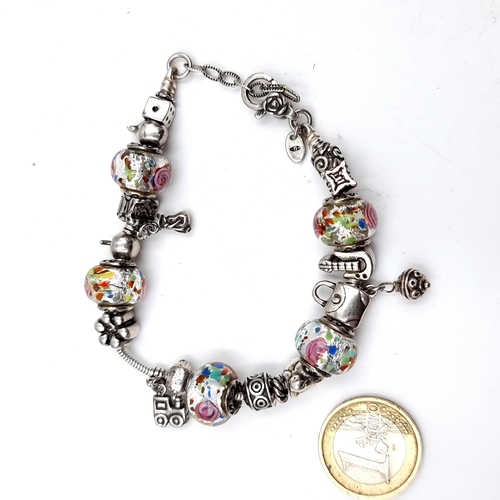 960 - A gorgeous sterling silver Pandora bracelet with a lobster clasp, five floral charms and others in t... 