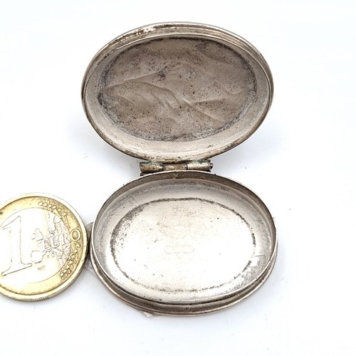 460 - An antique hinged sterling silver Pill box with repouse design. Weight 14gms.