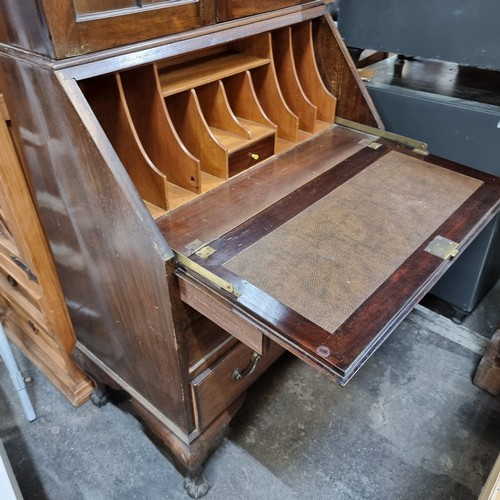 285 - A stately Edwardian secretary desk, circa 1910s, featuring rich mahogany with elegant glazed bar doo... 