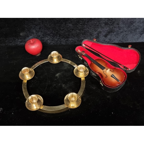 286 - An elegant brass candle holder, characterised by its circular form and a miniature Violin in a case.