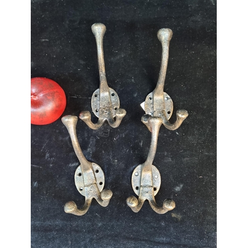 109 - A selection of four cast metal double coat hooks