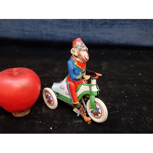 169 - A very fun vintage tinplate wind-up toy of a circus monkey riding a tricycle from Aya. Comes with wi... 