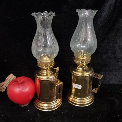 189 - Two pretty brass oil lamps complete with glass chimneys. Both in very good condition.