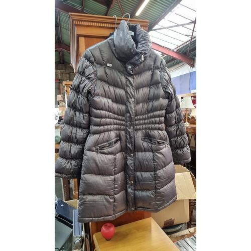 A fashionable Michael Kors designer down filled 3/4 length ladies winter coat. Very light but extremely warm. Features branded stud fastening and zip. Size medium. In very god condition, Similar online for €330