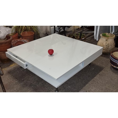 672 - A stylish large contemporary coffee table fitted with two drawers and held on chrome legs. In a slee... 