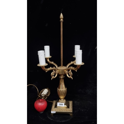 209 - A large solid brass four branch candelabra lamp. In good order, would take an American small hole sh... 