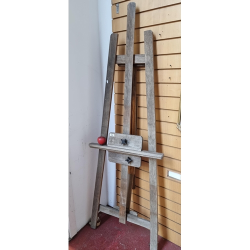 302 - A very large and heavy vintage artist's wooden tripod easel with adjustable canvas holder.