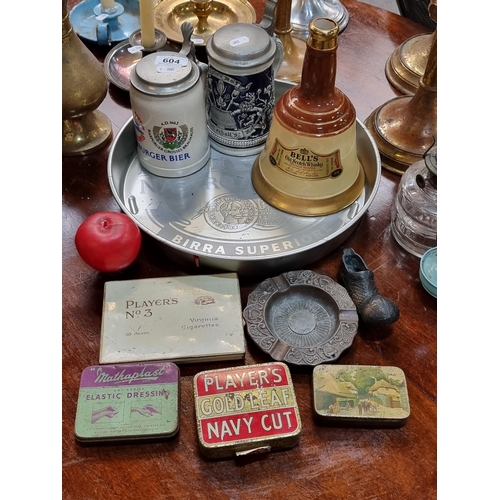 604 - A mixed vintage lot including two German made steins, a Bell's Scotch Whisky jar, a number of Player... 