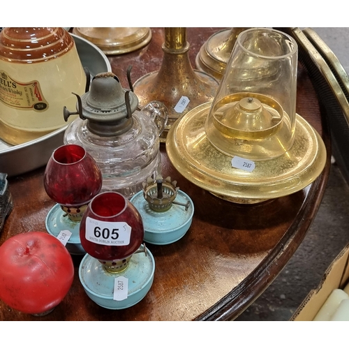 605 - Three dainty matching oil lamps with baby blue bases, two with original ruby glass shades. Along wit... 