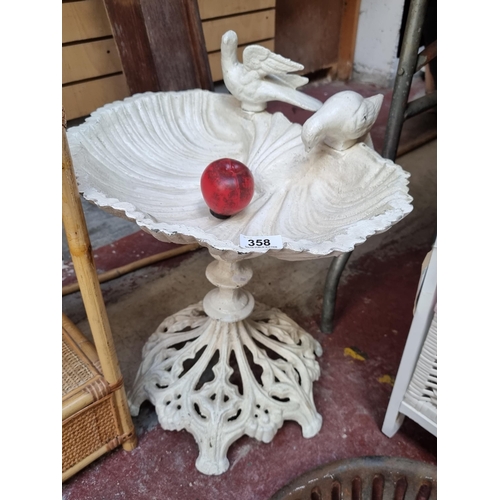 358 - Star Lot : An elegant cast iron garden bird bath with a basin in the form of a shell, two dove figur... 