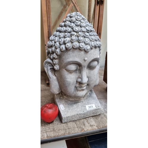 361 - A large statue depicting Buddha's head with closed eyes. In a light grey finish. H40cm