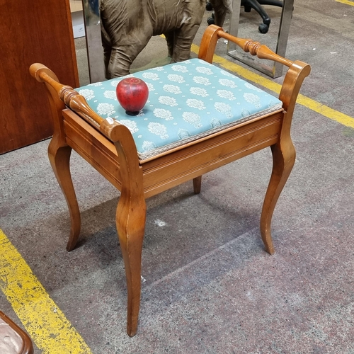 395 - A charming golden mahogany piano stool with turned handles and padded seat revealing sheet music  co... 