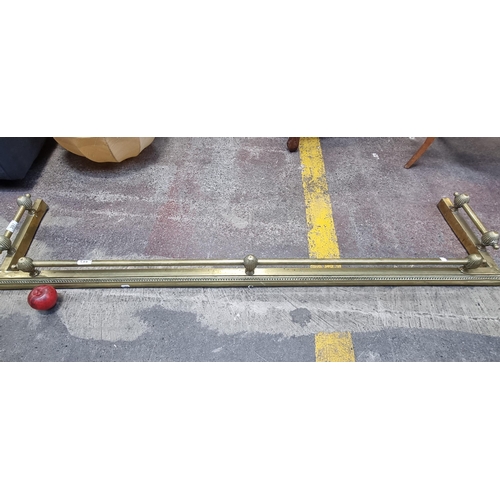 397 - An ornate vintage brass fire fender with gallery surround and reeded finials. L155cm x D36cm From a ... 