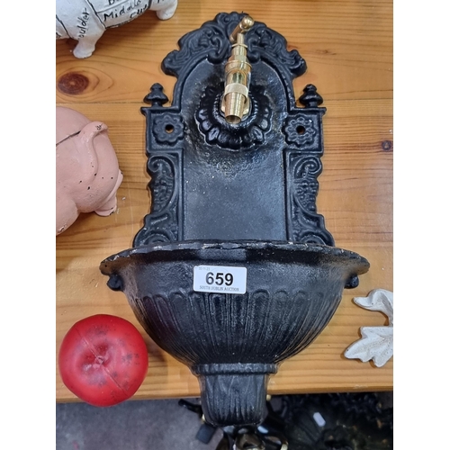 Star Lot A heavy cast iron wall mounted water fountain with brass tap.