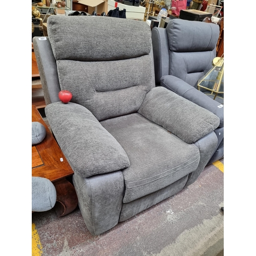 407 - Star Lot : A leather and fabric comfortable recliner armchair in a charcoal grey finish. This is in ... 