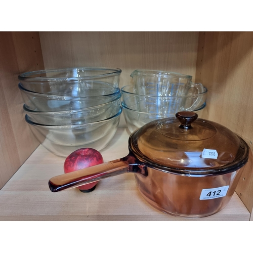 412 - A kitchen lot consisting of Pyrex ware including a saucepan, six mixing bowls and a measuring jug. (... 