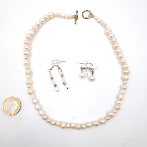 574 - A natural  fresh water pearl necklace, length 42cm, set with a T-bar clasp together with a pair of p... 