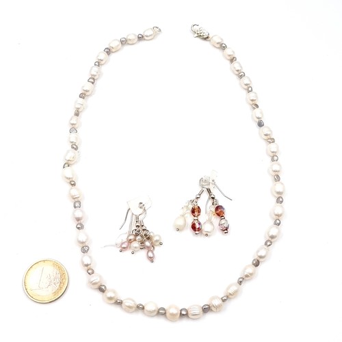 576 - A nice example of a natural fresh water pearl necklace set with smaller pearls accents, length 44cm,... 