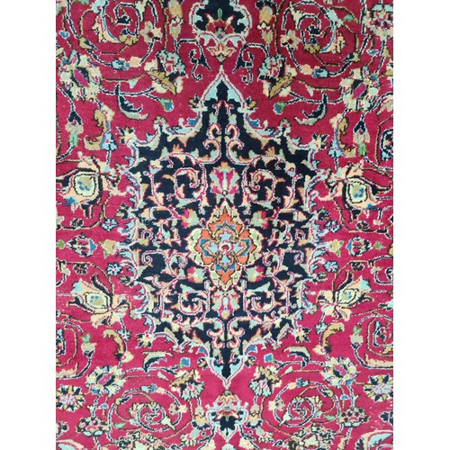 730 - A beautiful and very large hand knotted wool rug with a floral design in jewel tones of red and navy... 