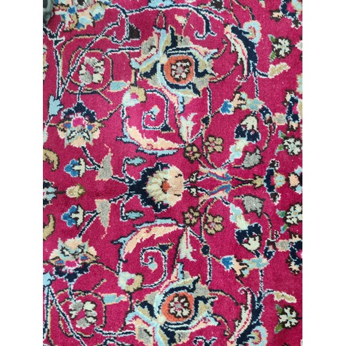 730 - A beautiful and very large hand knotted wool rug with a floral design in jewel tones of red and navy... 