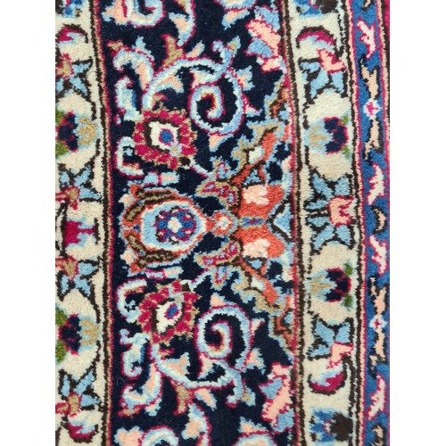 730 - A beautiful and very large hand knotted wool rug with a floral design in jewel tones of red and navy... 