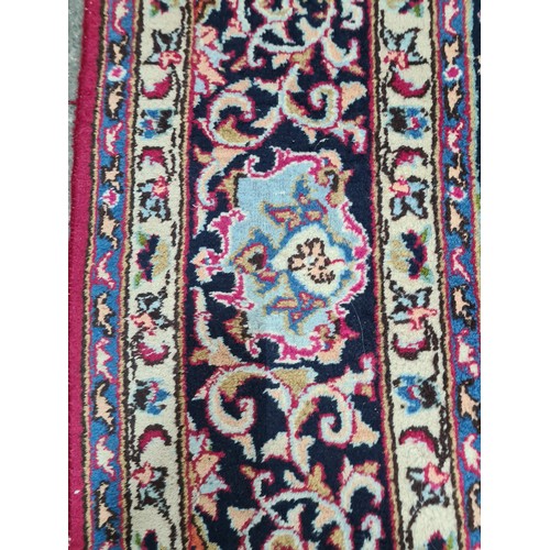 730 - A beautiful and very large hand knotted wool rug with a floral design in jewel tones of red and navy... 