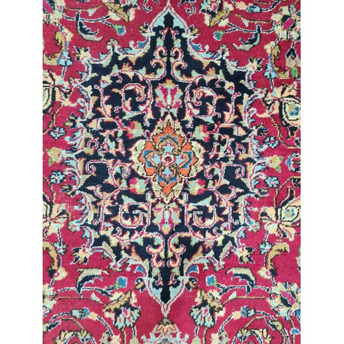 730 - A beautiful and very large hand knotted wool rug with a floral design in jewel tones of red and navy... 