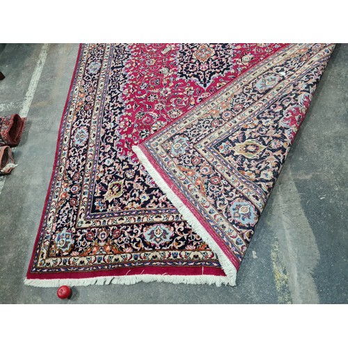 730 - A beautiful and very large hand knotted wool rug with a floral design in jewel tones of red and navy... 