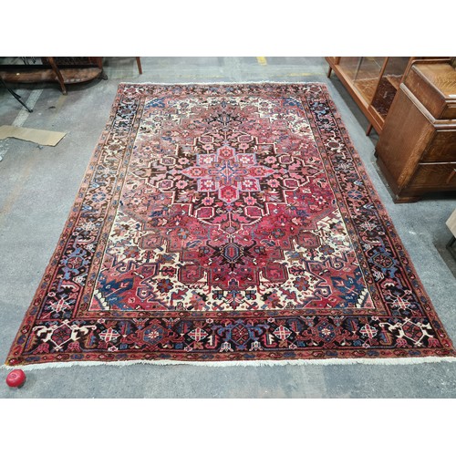 733 - Star Lot : A very large hand knotted wool rug boasting a floral and geometric design. L290cm x W212c... 