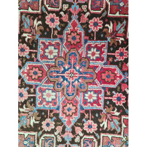 733 - Star Lot : A very large hand knotted wool rug boasting a floral and geometric design. L290cm x W212c... 