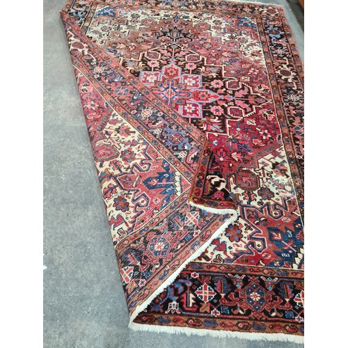 733 - Star Lot : A very large hand knotted wool rug boasting a floral and geometric design. L290cm x W212c... 