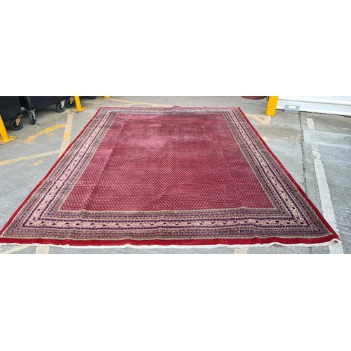 732 - Star Lot : A huge gorgeous hand knotted wool rug in a ruby red shade with an intricate geometric and... 